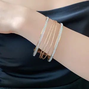 Close-up of elegant multilayer gold cuff bangle with glitter inlay on wrist
