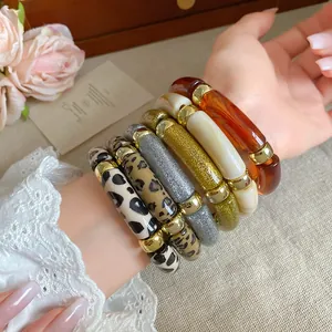 Primer plano de pulseras de acrílico con estampado de leopardo y purpurina de estilo retro.