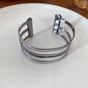Close-up of multi-layer metallic cuff bracelet with glitter and smooth finishes.