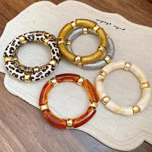Detalle de brazaletes coloridos de resina acrílica con estampados de leopardo y carey