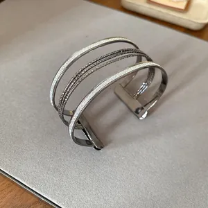 Macro view of a stylish multi-layer metal open bangle featuring a sparkling glitter finish