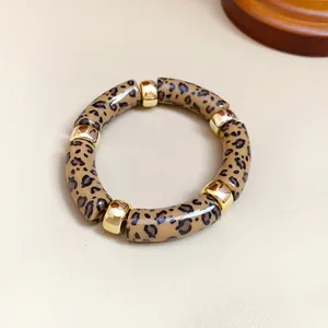 Vista detallada de una pulsera de acrílico con estampado de leopardo y piezas doradas