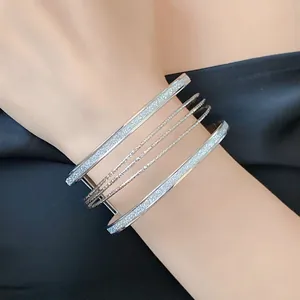 Detailed view of silver multi-layer metallic cuff bracelet with glittery textured finish