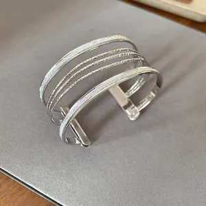 Close-up of silver multi-layer cuff bracelet with glitter and polished bands