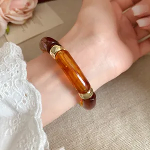 Primer plano de una pulsera de acrílico jaspeado ámbar vintage con detalles dorados