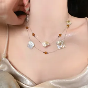 Elegant double-layered necklace featuring irregular square shells and vibrant orange glass beads