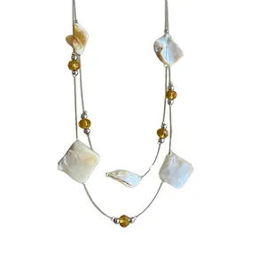 Elegant double-layer necklace featuring irregular shell pieces and amber glass beads