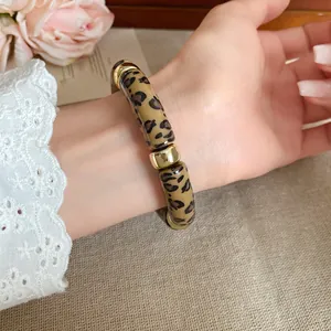 Vista detallada de una elegante pulsera de acrílico con estampado de leopardo y oro