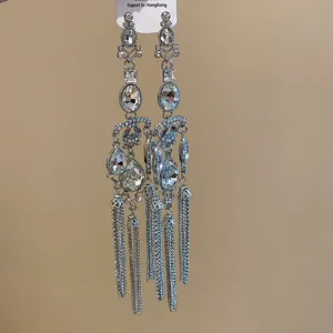 Detailed macro view of glamorous sparkling rhinestone drop tassel earrings in silver finish.