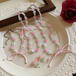 Detail view of colorful beaded flower necklaces and earrings on a decorative plate