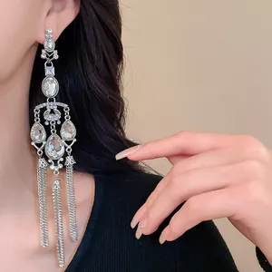 Close-up of silver-plated tassel earrings with water drop rhinestones on a model