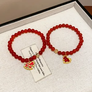 Elegant red agate bead bracelet featuring a gold rocking horse charm and clear quartz
