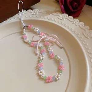 Handmade pastel beaded flower phone charm accessory featuring a cute pink beaded bow
