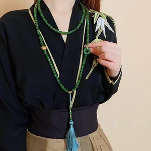 Elegante lange Halskette im neuen chinesischen Stil mit grünen Perlen und blauer Quaste.