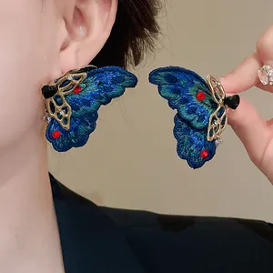 Vista dettagliata di orecchini vintage a farfalla blu con dettagli a cuore e cristalli
