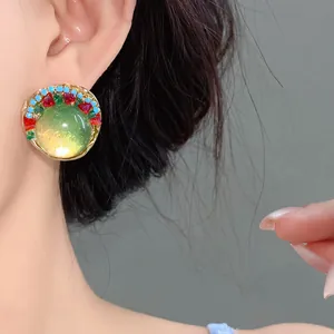 Macro view of a French vintage resin earring with green glass center and colorful beads.