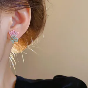 Close-up of handmade beaded tulip earring worn on ear, sweet pastoral style jewelry.
