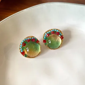 Macro detail of elegant vintage French resin earrings with colorful bead accents and gold trim