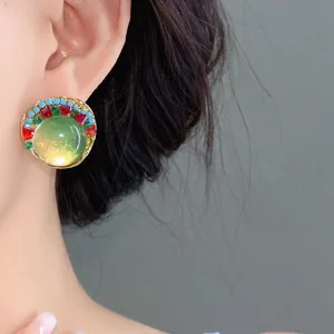 Close-up of vintage French style round resin beaded earring with green glass cabochon