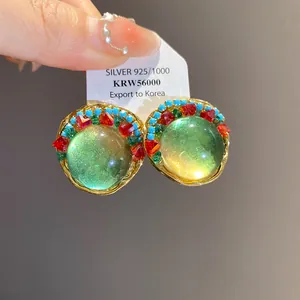 Detailed view of French vintage earrings with green resin cabochon and colorful beads