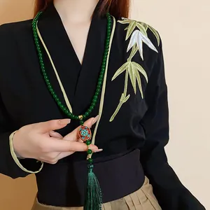 Detailaufnahme einer neuen chinesischen Halskette mit grünen Perlen und Seidenquaste