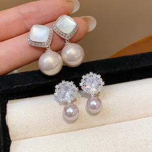 Exquisite detail of silver flower earrings with sparkling zircons and white pearls.