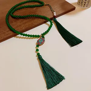 Elegante ethnische grüne Perlenkette mit dekorativer Cloisonné-Perle und Seidenquasten