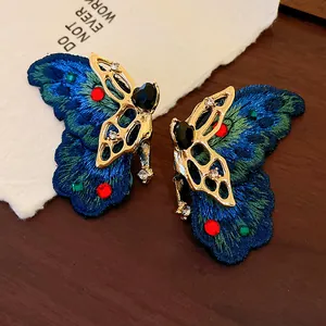 Primo piano di orecchini a farfalla ricamati vintage con cornice dorata e cristalli