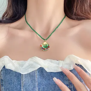 Close-up detail of a French vintage green resin pendant necklace worn on a model