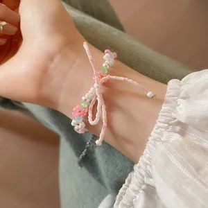 Close-up of a sweet pastoral style beaded bracelet with a pink bow and white pearls