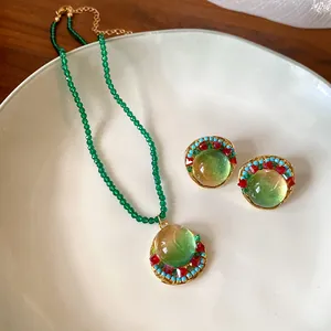 Detail of vintage French green beaded necklace and gradient resin earring set.
