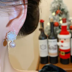 Close-up of elegant snowflake flower earring with cubic zirconia and a dangling round pearl