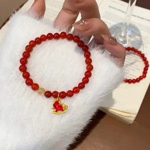 Red agate beaded bracelet with gold rutilated quartz bead and a gold horse charm