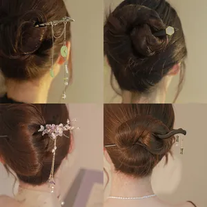 Vue détaillée de quatre épingles à cheveux chinoises en bois avec des pompons élégants
