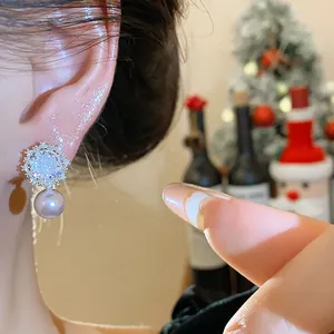 Detailed macro view of silver needle zircon flower pearl earring on a model's ear