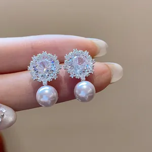 Detailed close-up of exquisite zircon flower stud earrings featuring elegant round pearl drops