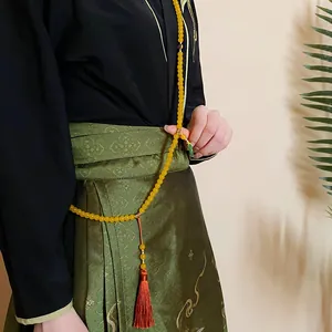 Detail der gelben Perlenkette im neuen chinesischen Stil mit Quaste, als Hüftkette getragen