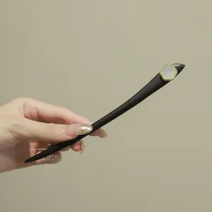 Gros plan détaillé d'un élégant pic à cheveux en bois avec un ornement de fleur.