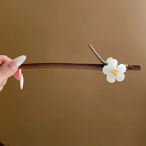 Gros plan d'un pic à cheveux en bois avec un élégant motif de fleur de prunier