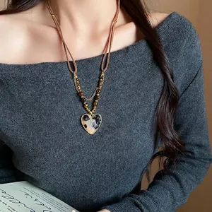 Vintage Maillard style heart pendant necklace with tiger eye stone worn by a model