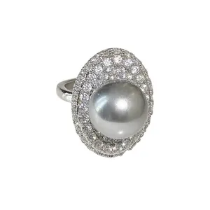 Bague élégante en argent avec une grande perle grise entourée de cristaux brillants.