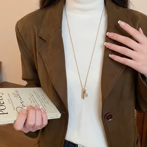 Elegante collana dorata con ciondolo a forma di pettine e specchio dal design unico