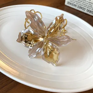 Macro detail shot of a vintage gold lily flower cuff bracelet with pearlescent petals
