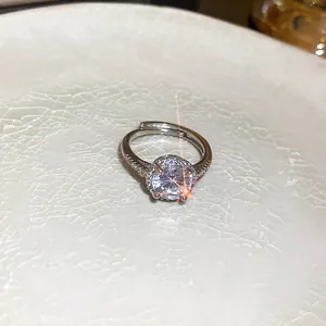 Vue détaillée d'une bague halo ronde scintillante avec anneau réglable et éclat de pierre