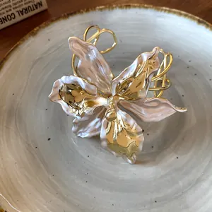 Detailed view of an elegant vintage lily flower cuff bracelet in gold and pearl white.
