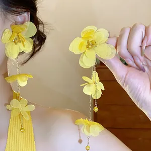 Detailed view of handmade yellow chiffon flower tassel earrings with golden chains.