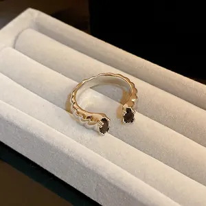 Gros plan d'une bague ouverte argentée texturée avec deux pierres noires en marquise