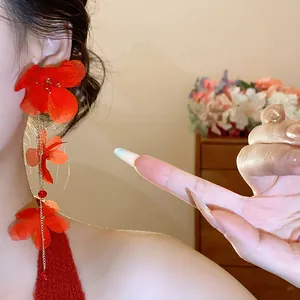 Detailed close-up of long red chiffon flower tassel earrings for a sweet vacation style