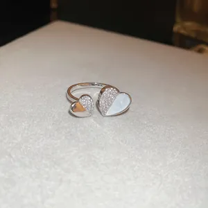 Gros plan d'une bague cœur avec strass et incrustation blanche