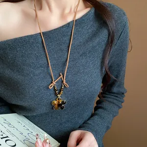 Detail view of a vintage-style Maillard tiger eye flower pendant sweater necklace
